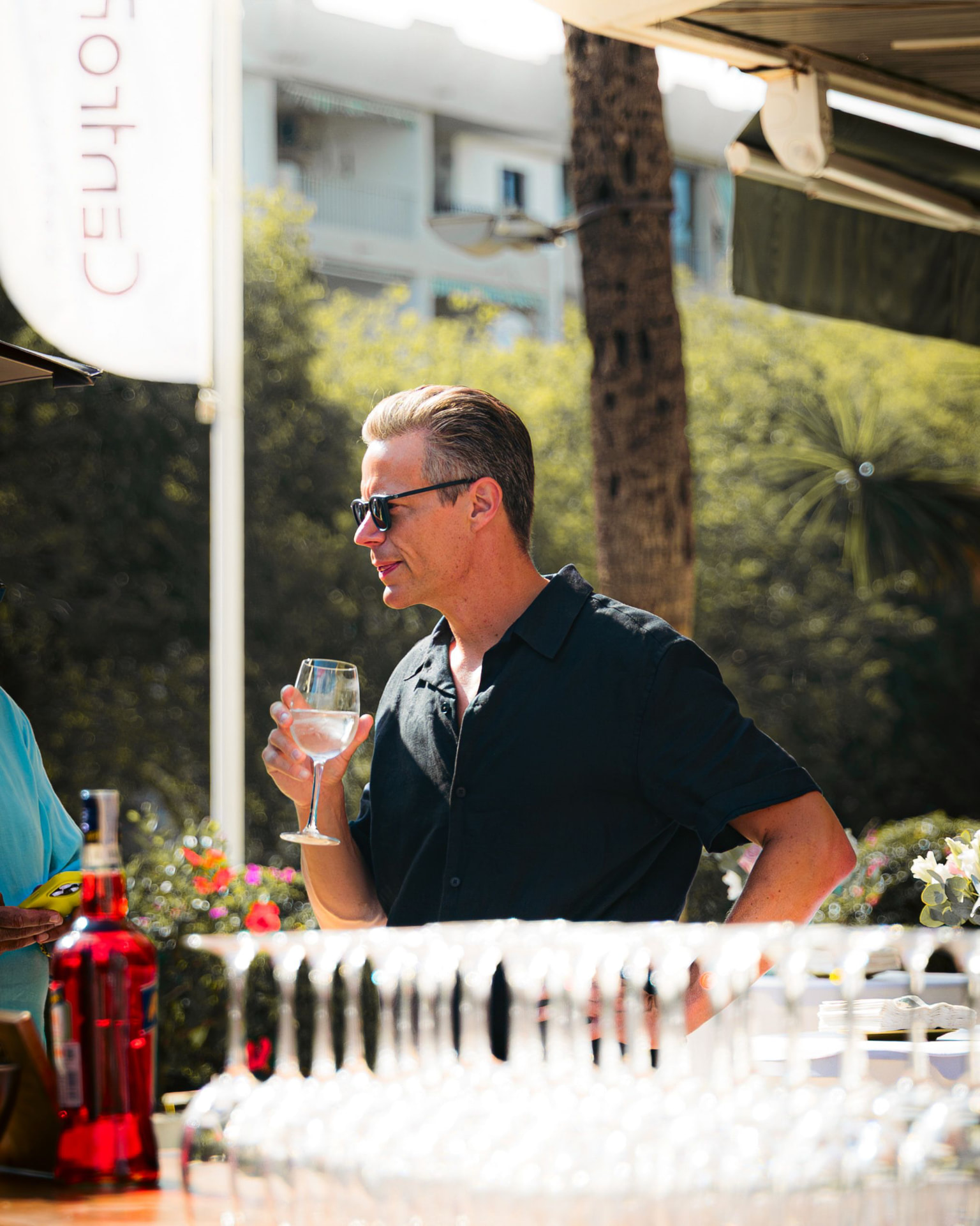 Guest holding a glass of wine at a sunlit outdoor event on the Costa del Sol